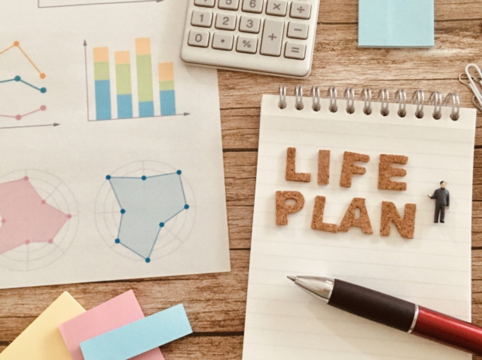 LIFE PLANと書かれたノート、電卓、グラフの資料