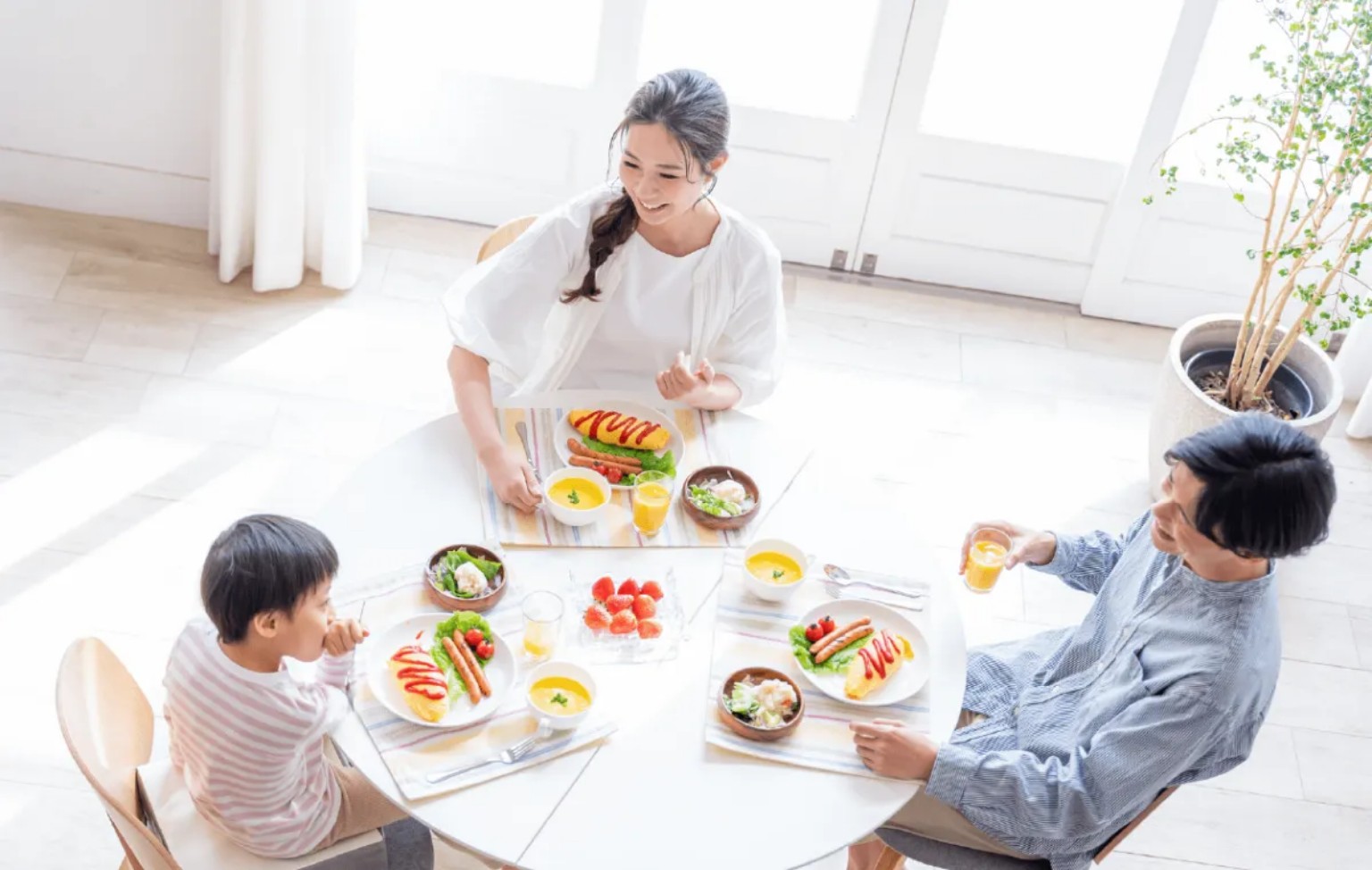 明るい部屋で食卓を囲む家族
