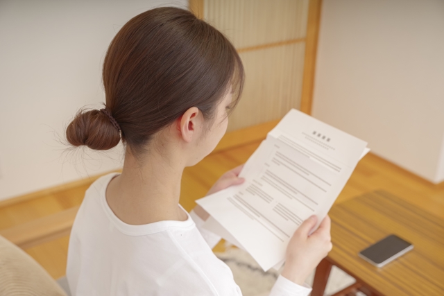 自宅で書類を確認する女性のイメージ