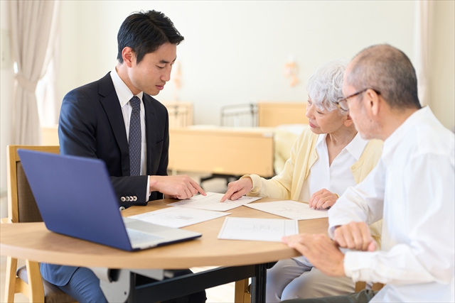 お客様に資料を示して説明する営業担当者のイメージ