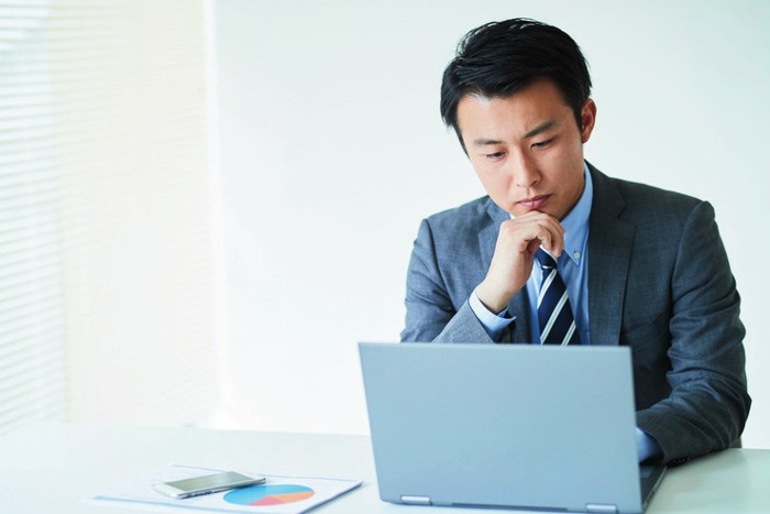 パソコンを前に考える経営者のイメージ