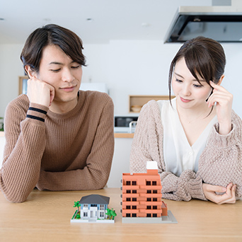 住宅の模型を見ながら考える二人