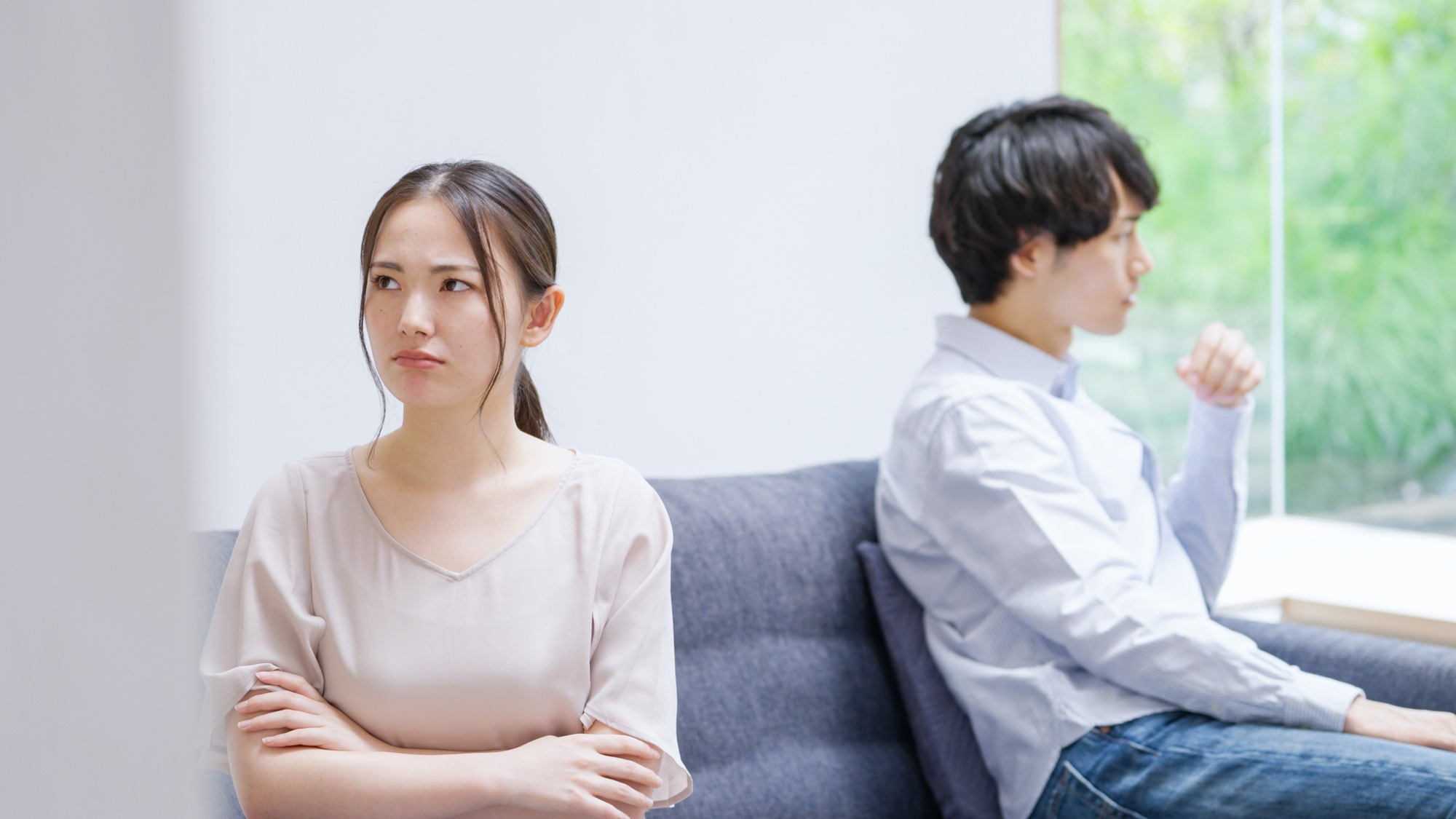 ソファで背を向け、それぞれ考える二人