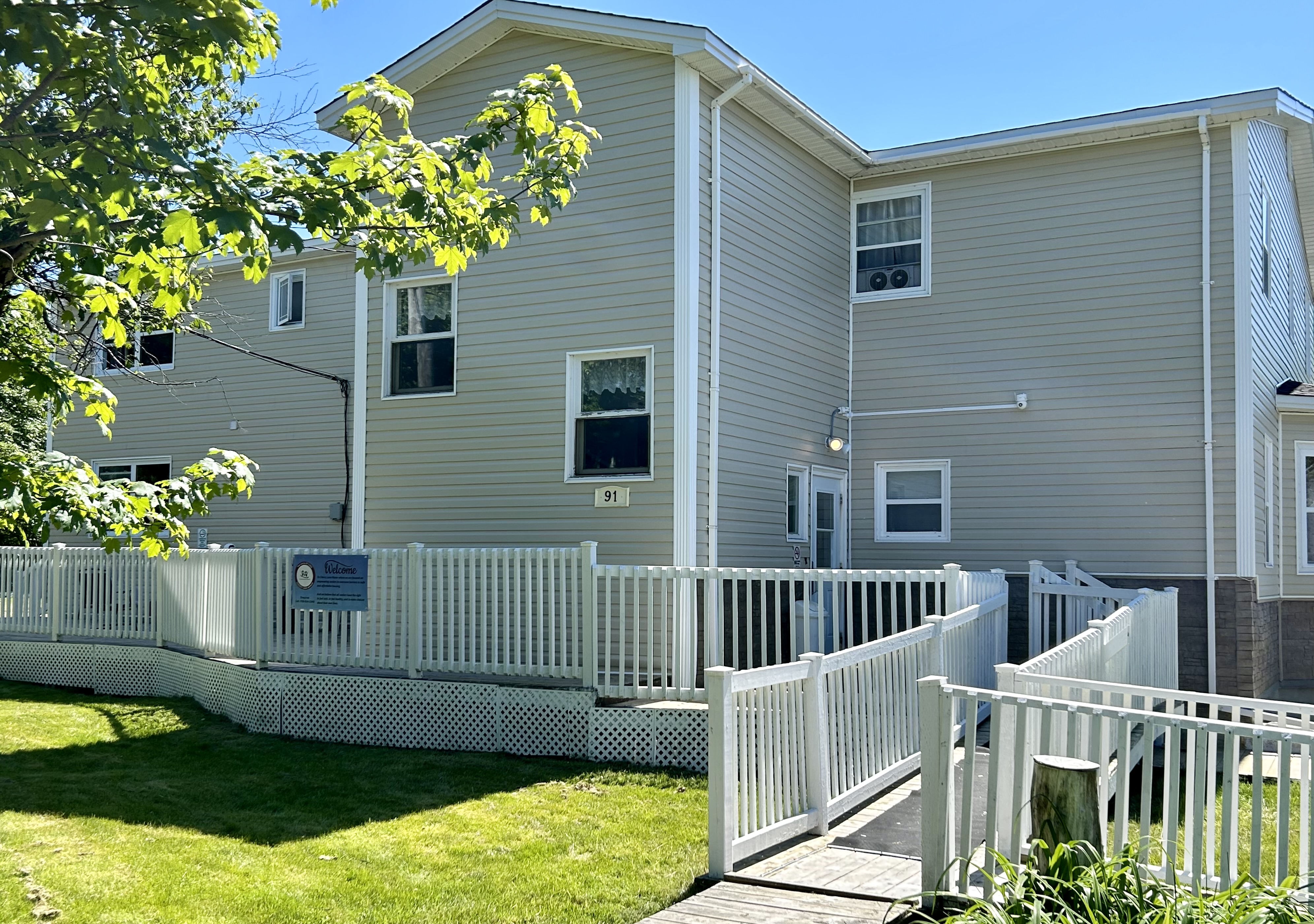 The outside of a Connections for Seniors apartment building with a white accessibility railing