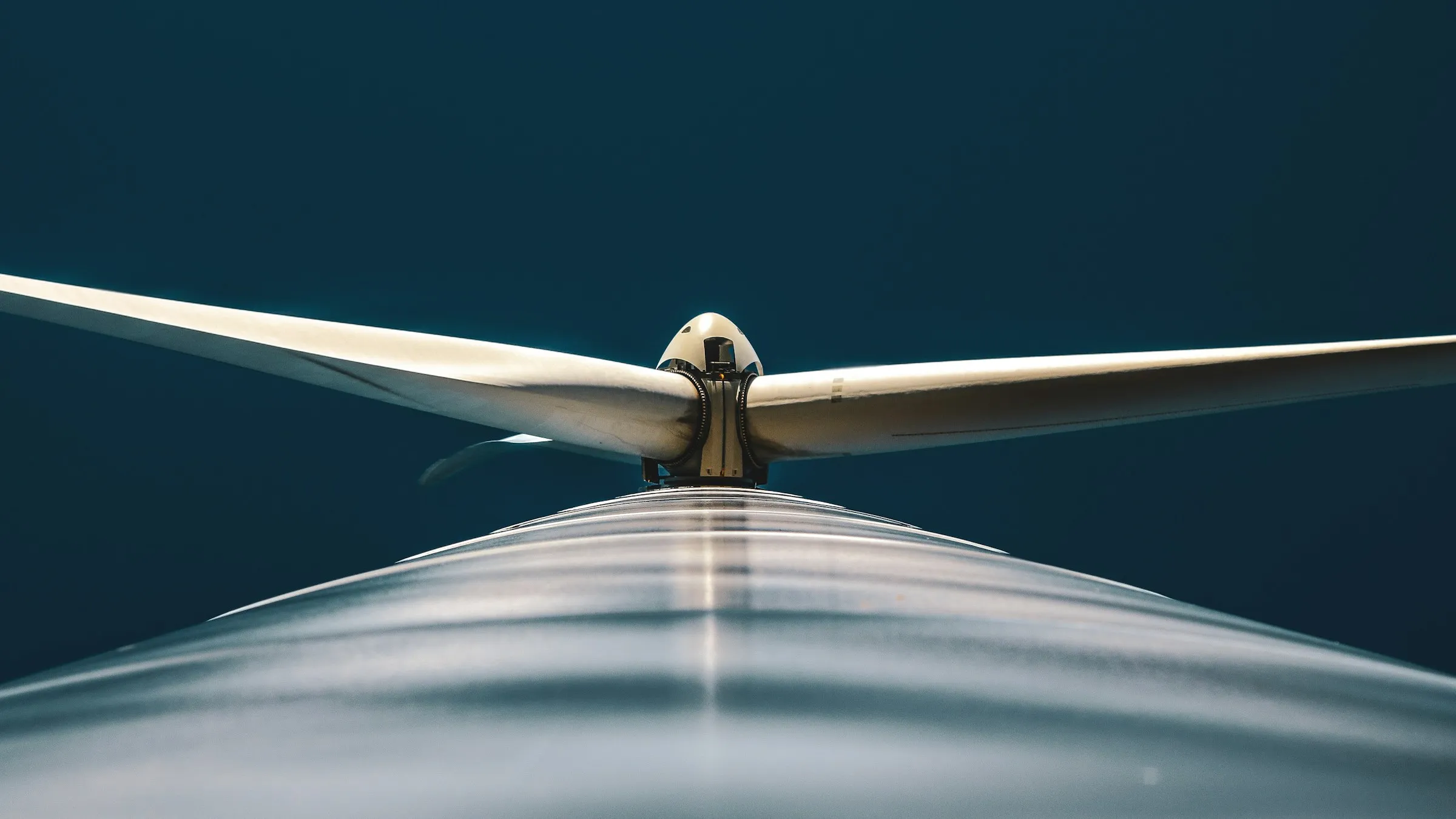 Close-up of a wind turbine nacelle and blades against a dark sky