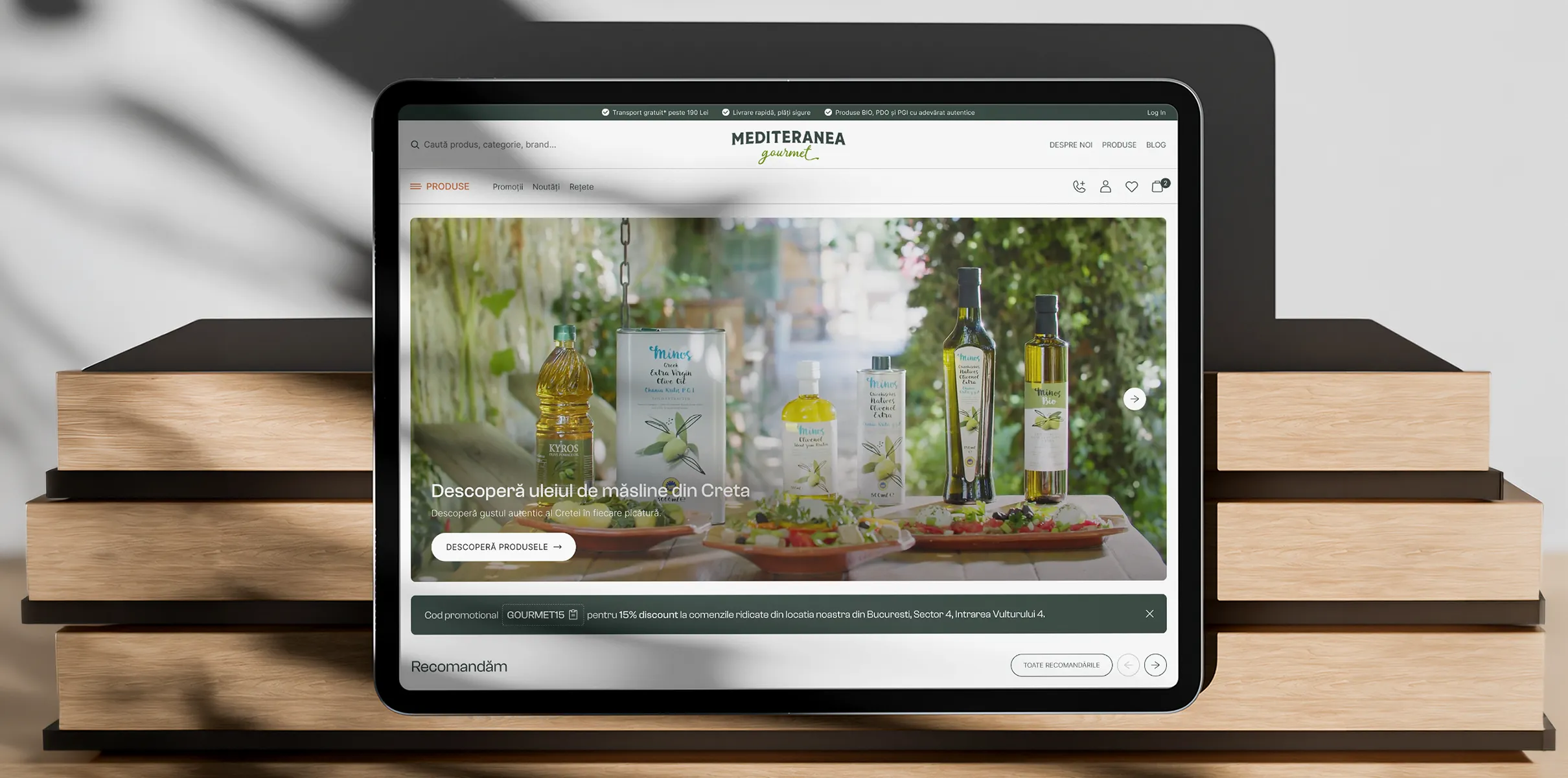Tabletă pe un teanc de cărți cu magazinul online Mediteranea Gourmet