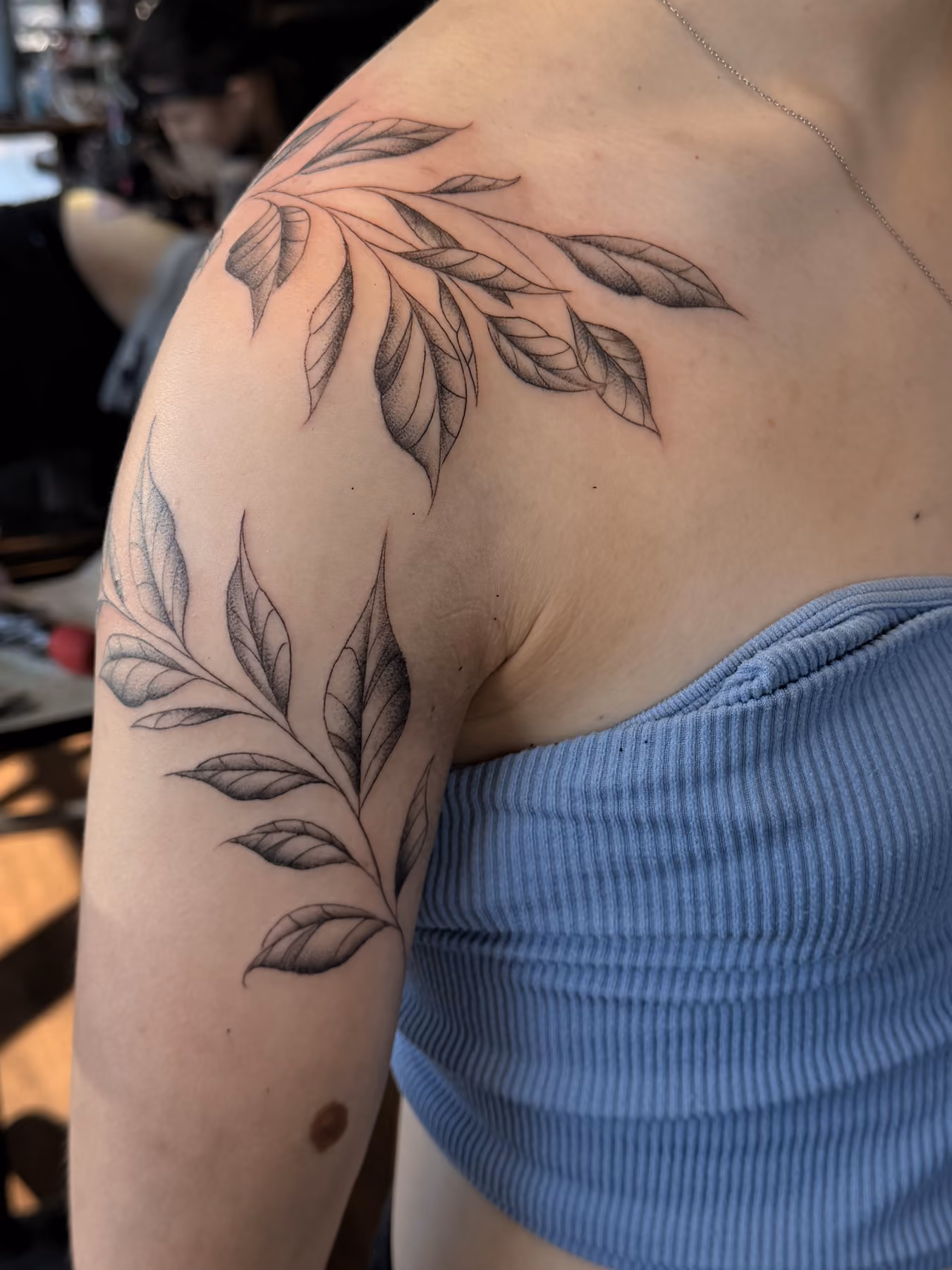 Fine line leaves and branches shoulder tattoo