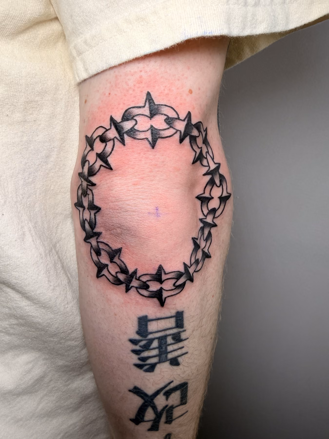 Blackwork thorn crown tattoo with lettering