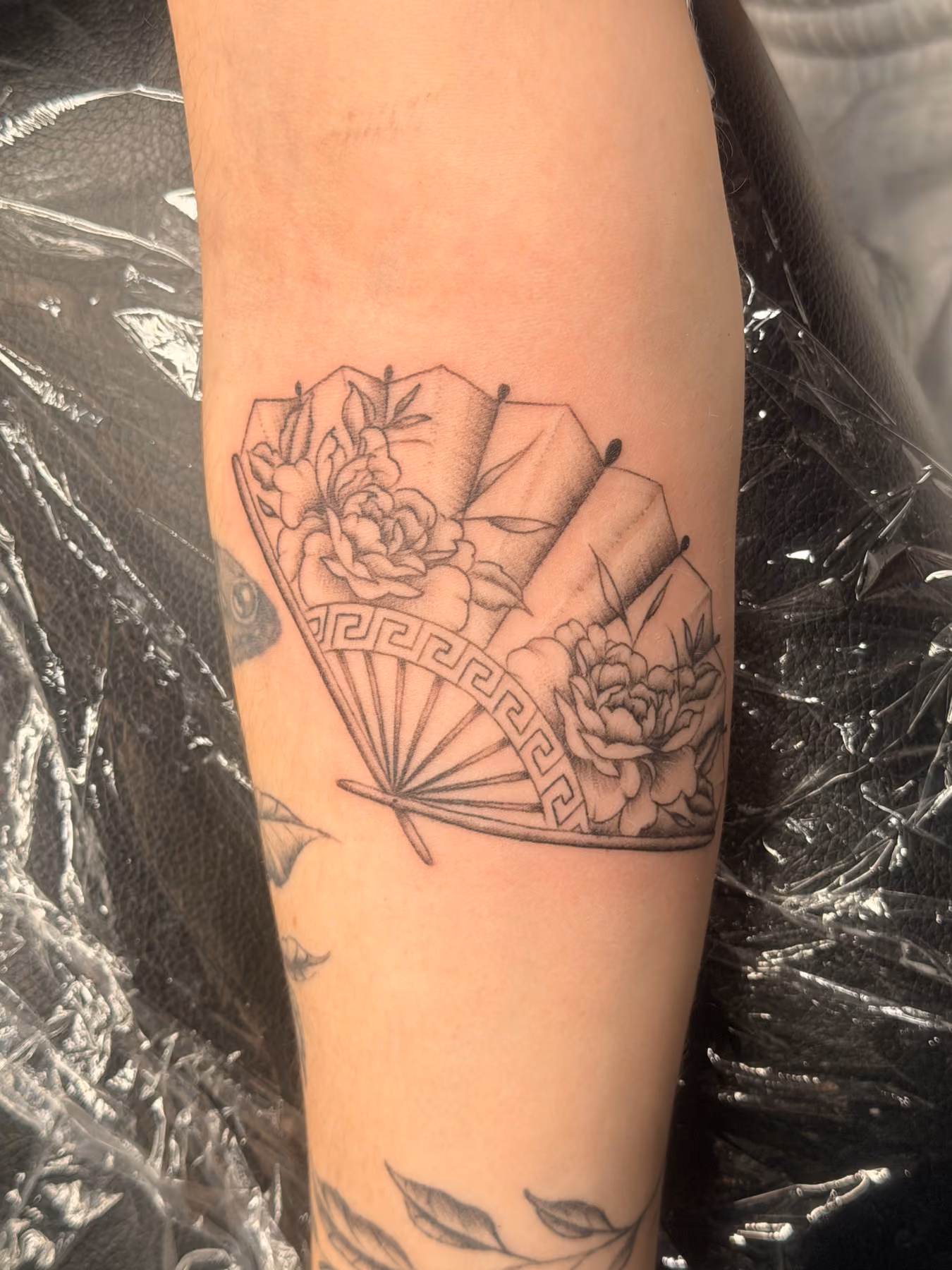 Fine line fan and flower tattoo by a Poughkeepsie tattoo artist
