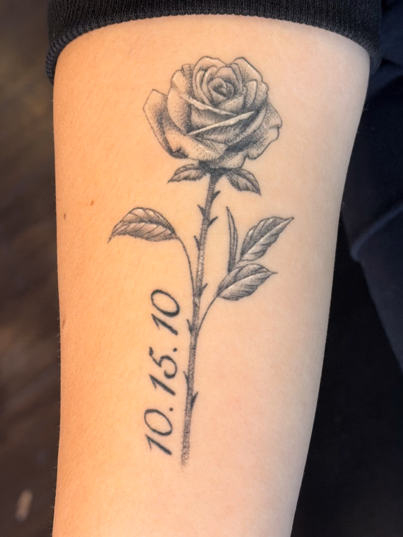 Black and grey rose tattoo with memorial date