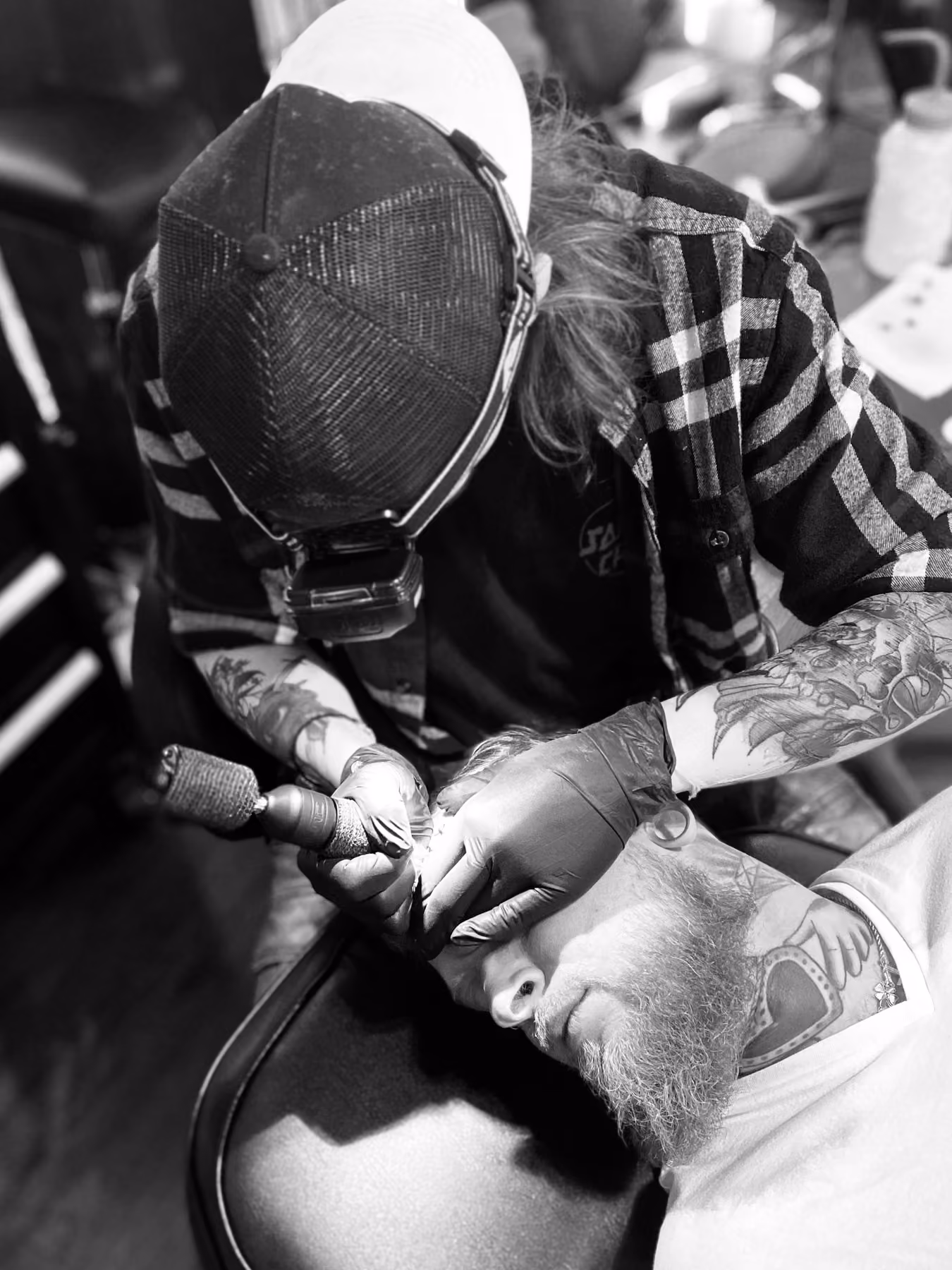 Tattoo artist at work on a client's arm at Thorn & Dagger Ink