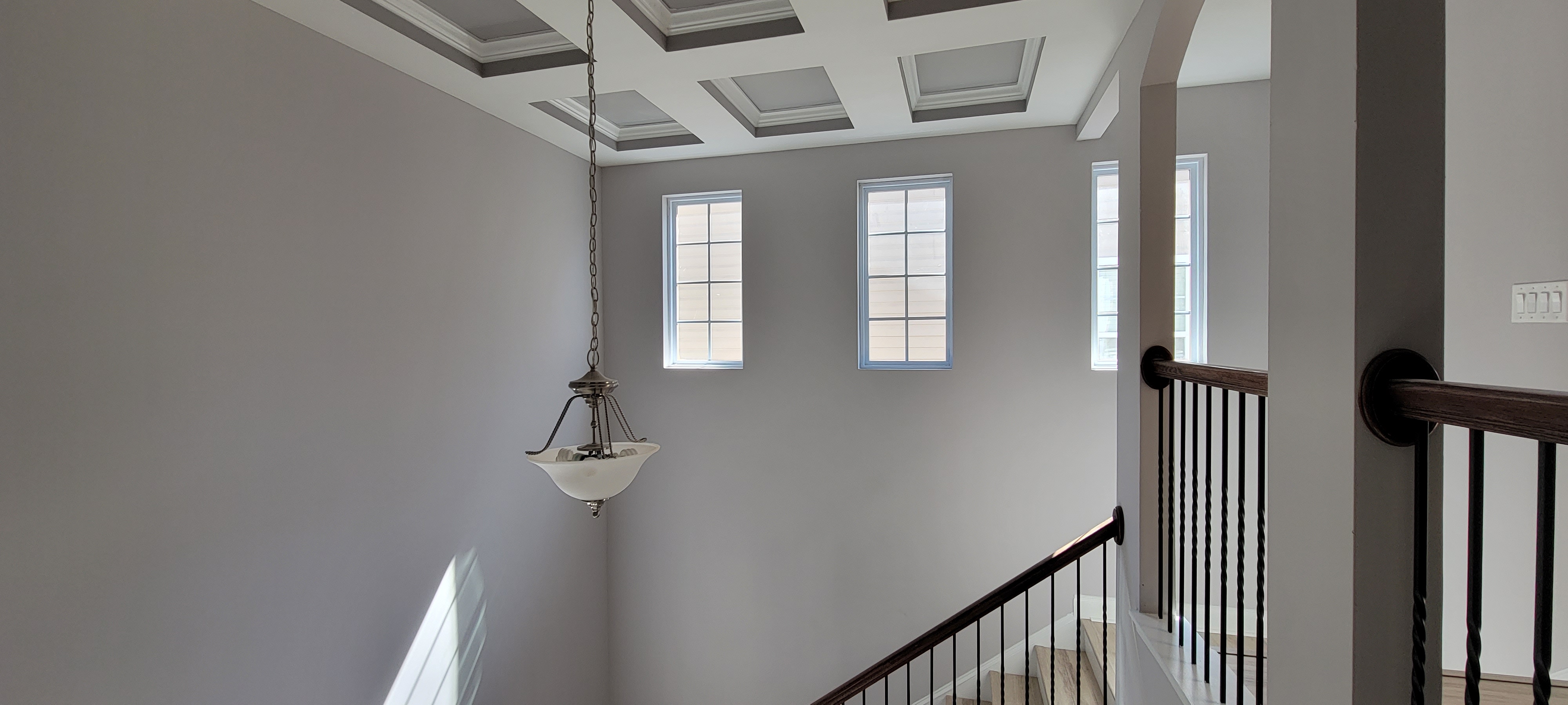 Freshly painted stairwell with coffered ceiling by PaintSmart