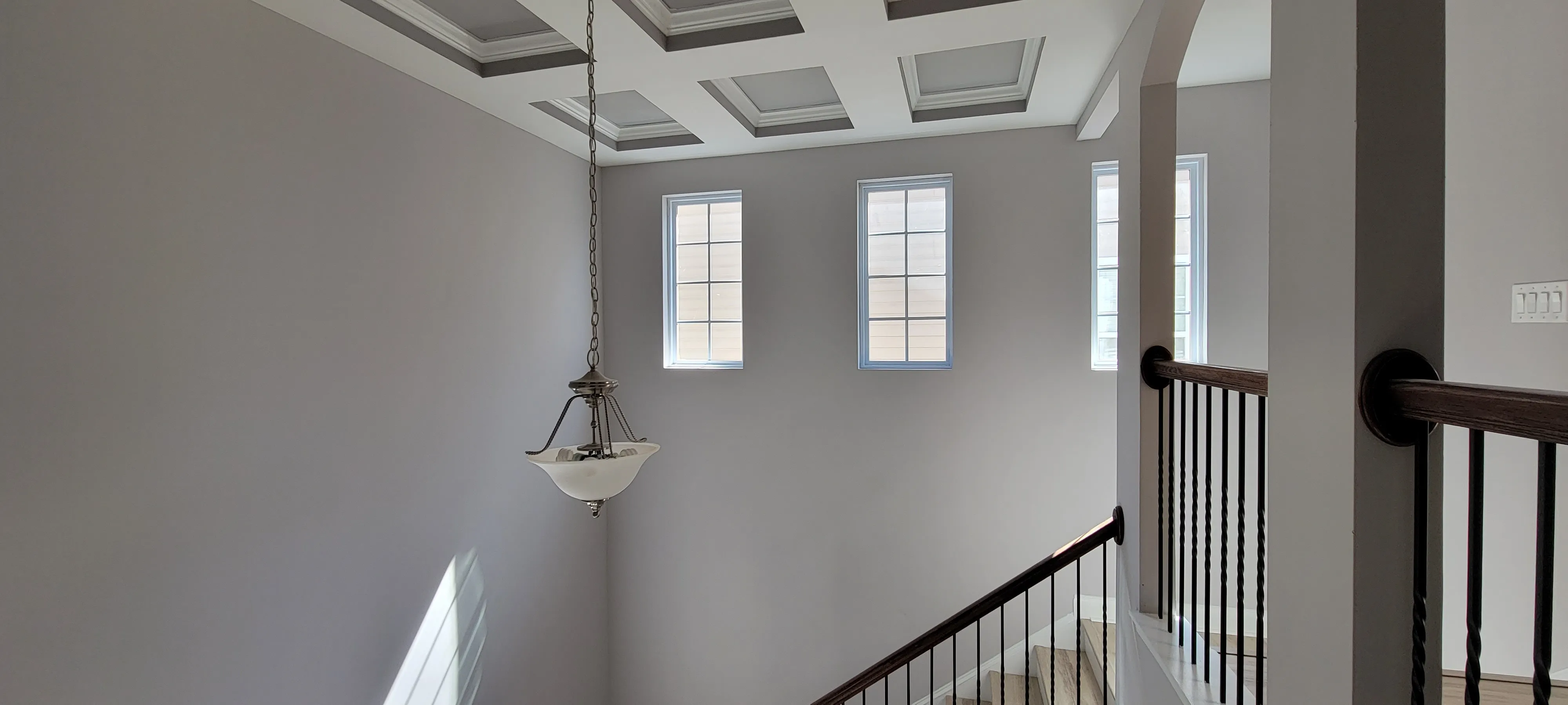 Freshly painted stairwell with coffered ceiling by PaintSmart