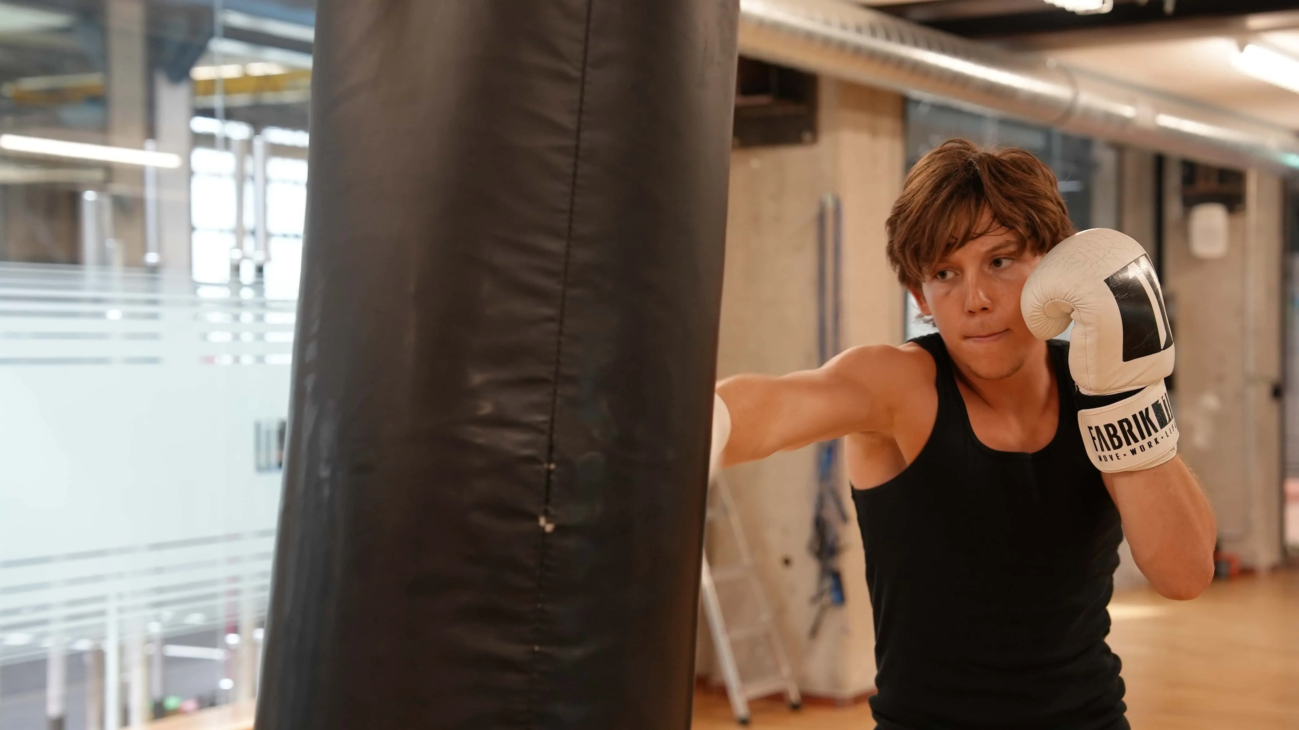 Teilnehmerin schlägt beim Boxtraining für Frauen und Männer auf den Sandsack