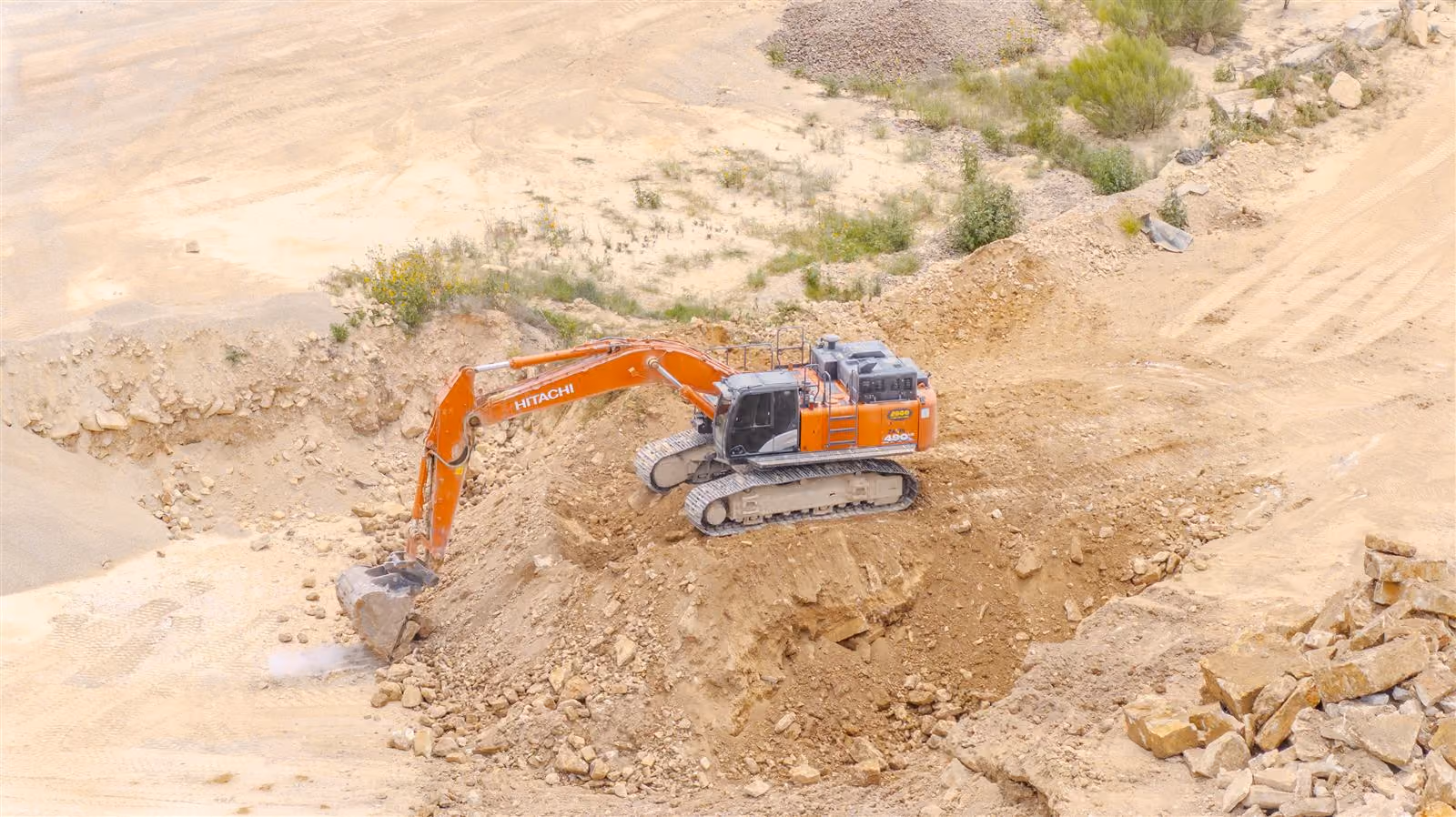 Excavator digging limestone on a slope at Heartland Aggregates