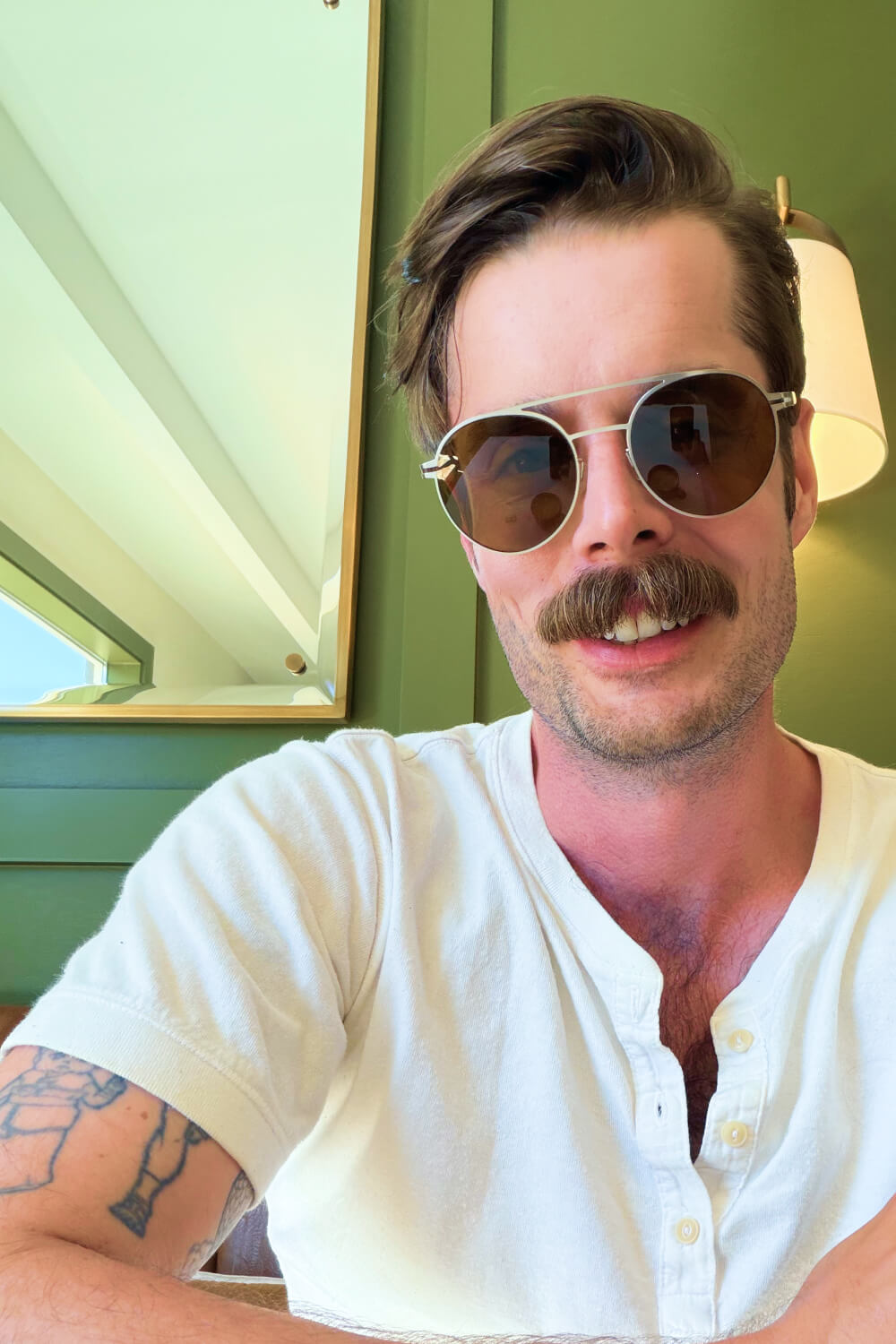 Photo of Alexander wearing sunglasses in a green cafe