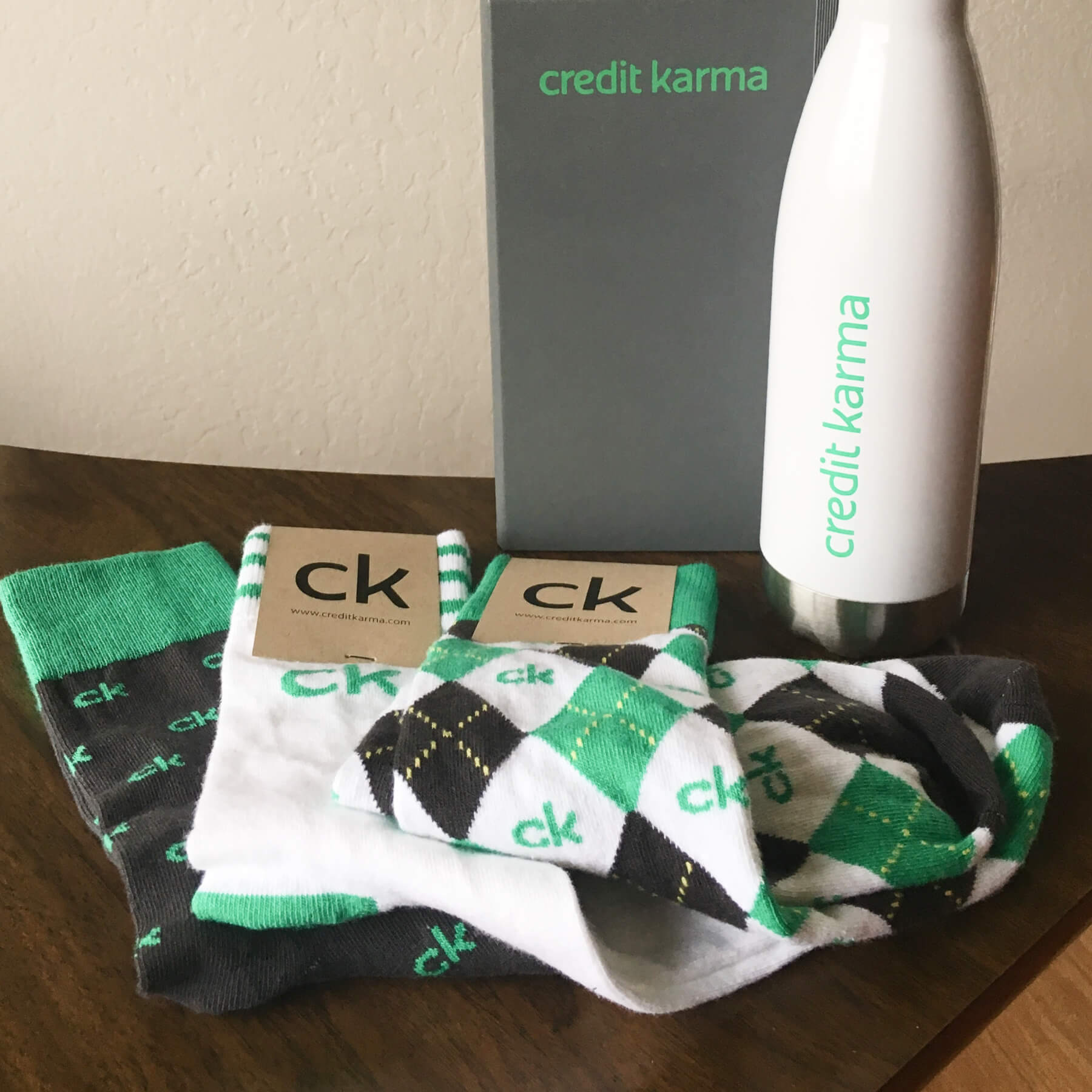 Examples of Credit Karma SWAG such as socks, a notebook, and a metal water bottle.