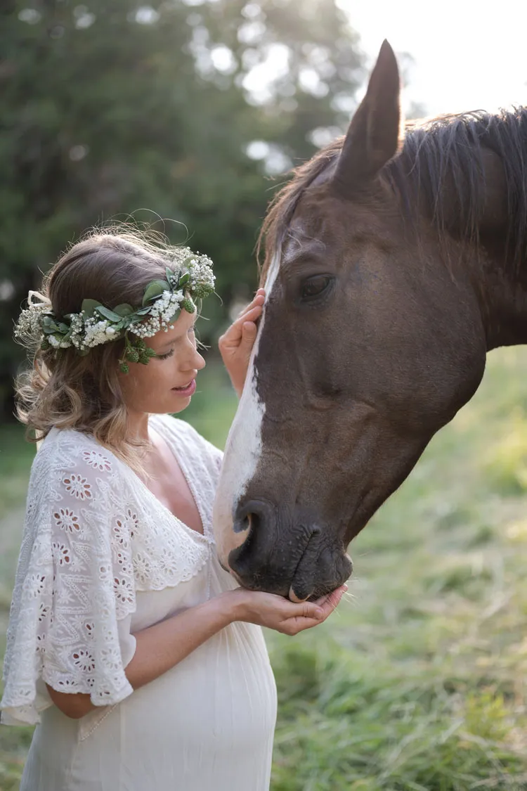 Donna in gravidanza accarezza cavallo
