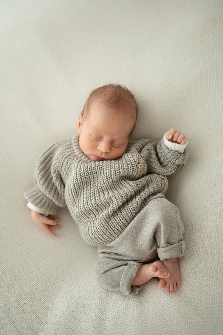 Neonato con tutina che dorme