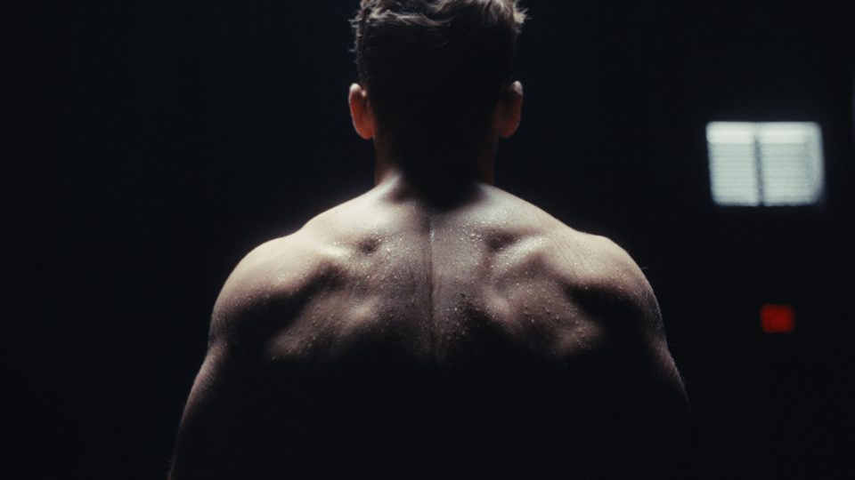 Fighter Kevin Solett from behind, sweat on his back in low light — From the Ground Up, a fight promo by MindWalk Pictures