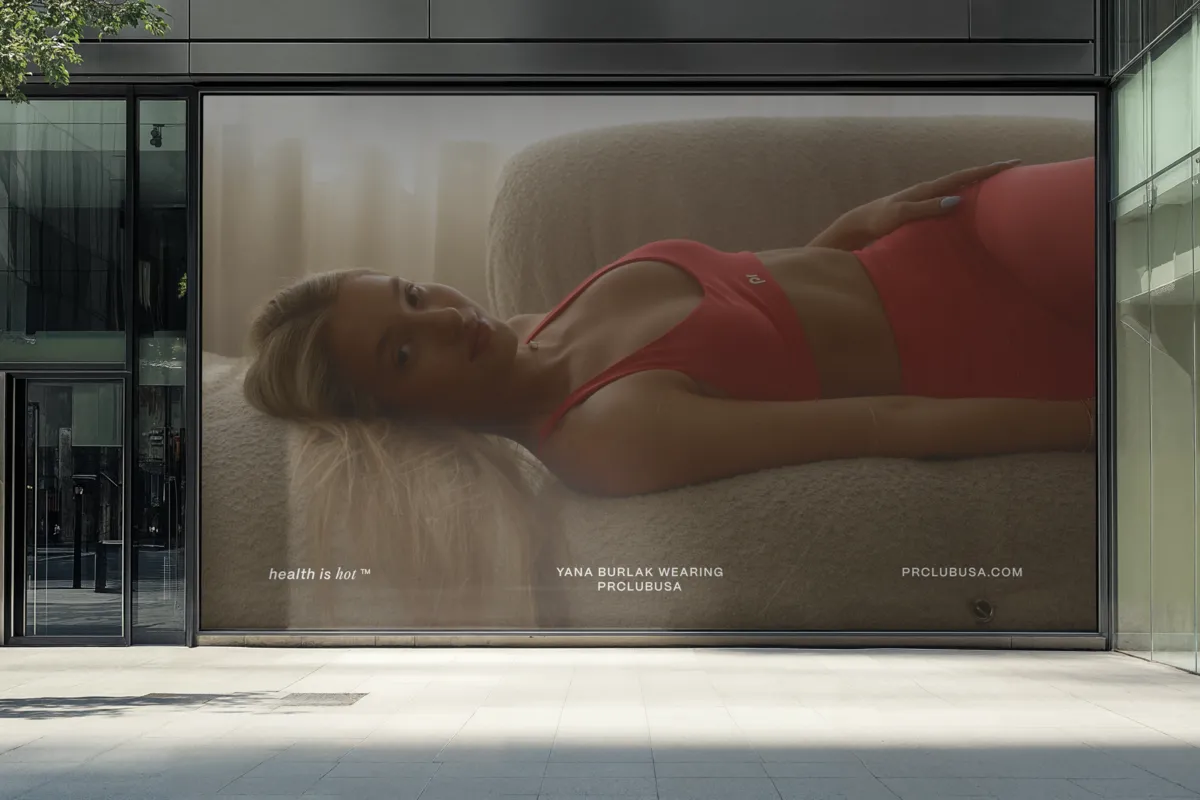 Storefront window mockup displaying a photo of Yana Burlak lying on the sofa in the red Winter Rose set