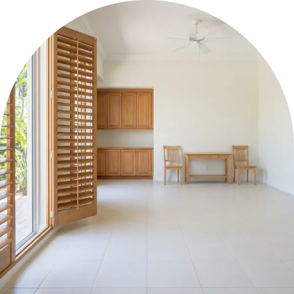 Bright room with white tile floors, open wooden shutters to the garden and a small wooden table with two chairs