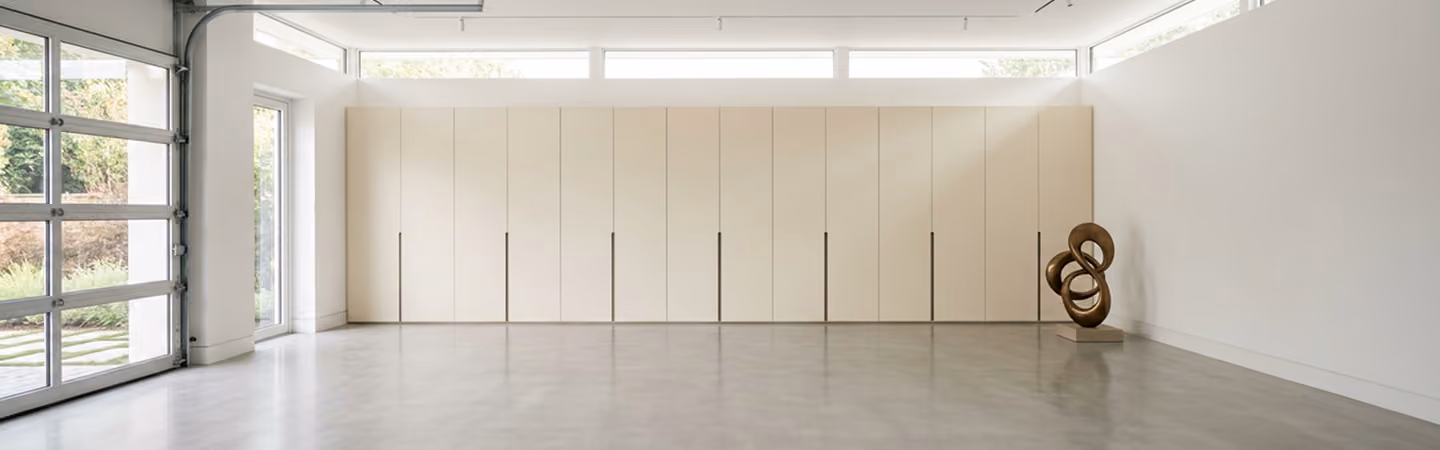 Spacious, uncluttered garage with a full wall of pale built-in storage cabinetry