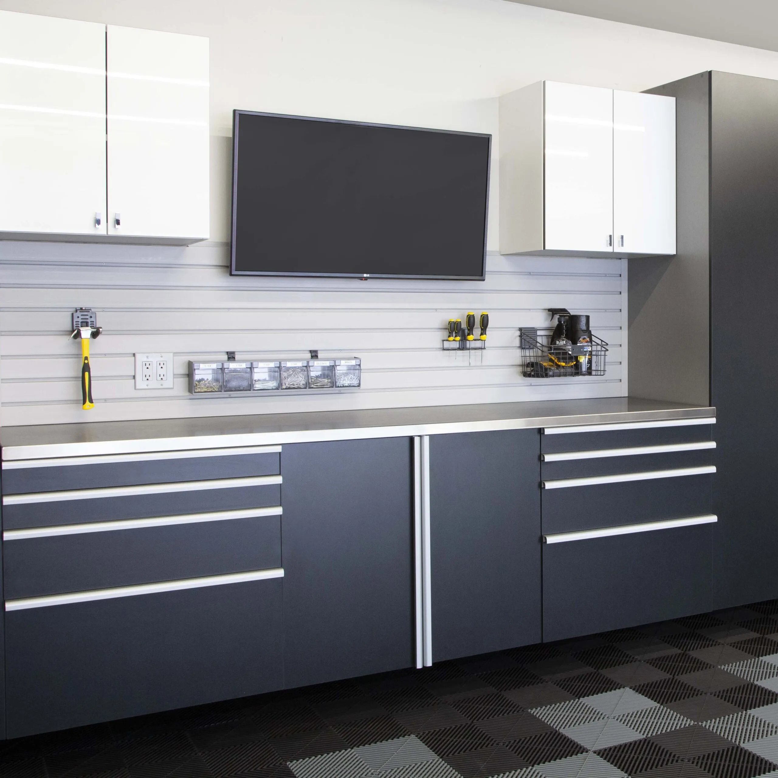 Garage with charcoal grey cabinetry, white wall panels and checkered flooring