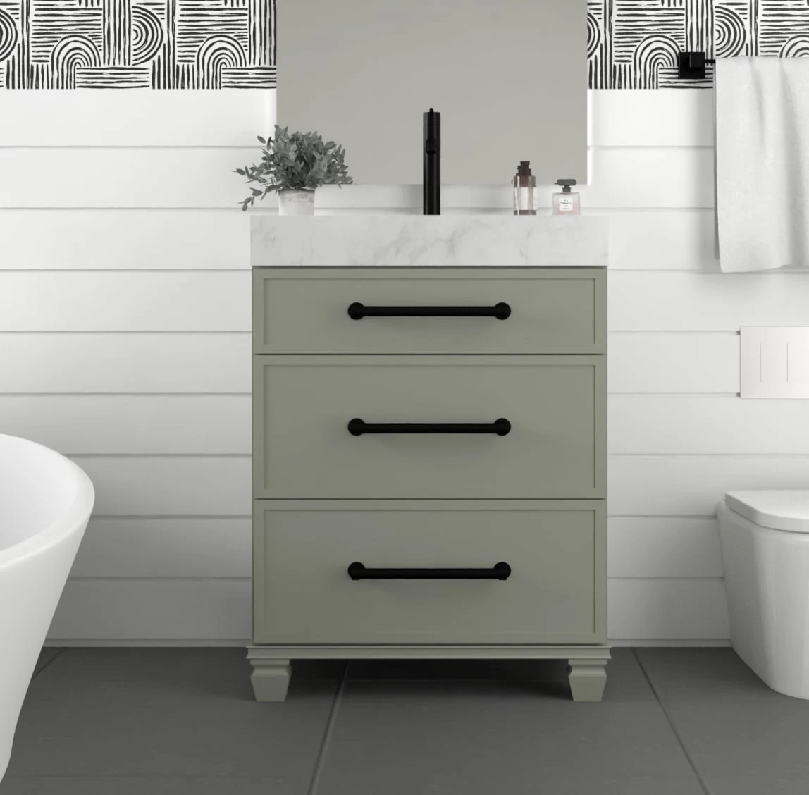 Sage green three-drawer bath vanity with black pulls against white shiplap walls