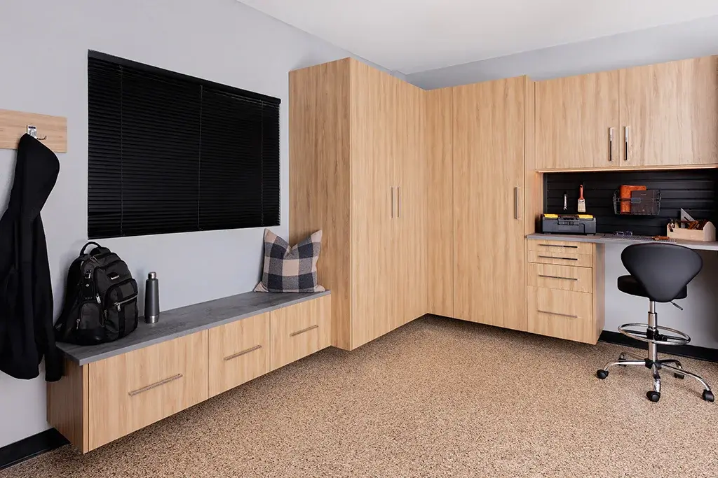 Garage workspace with light oak cabinetry and a built-in desk