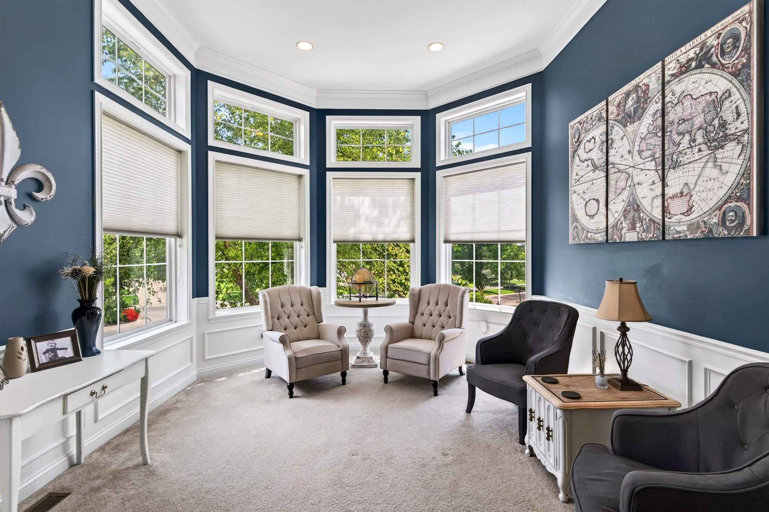 Window-lined sitting room with blue walls and white trim