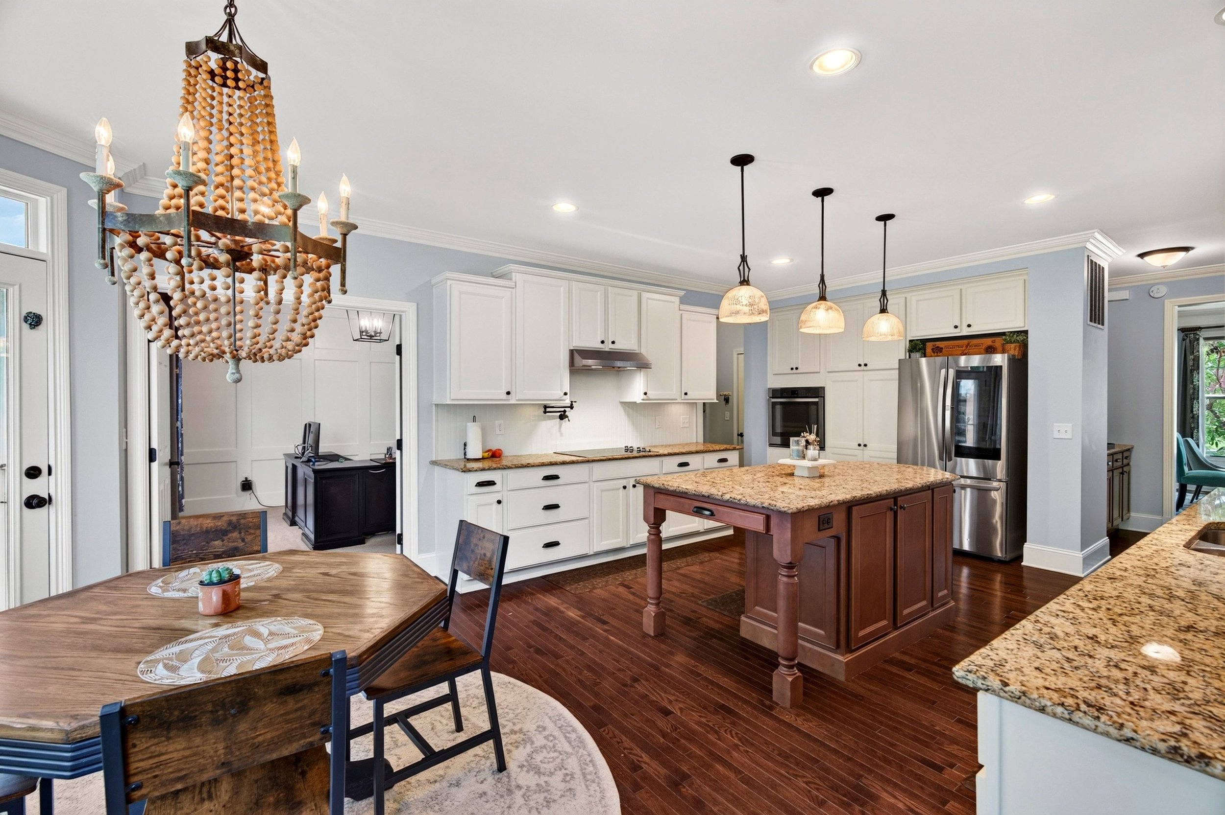 Kitchen with contrasting island, white cabinets, and adjoining breakfast area