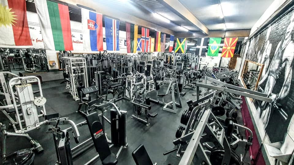 The free-weights floor at Definition Gym, Peterborough, with the full-length dumbbell rack and squat racks behind