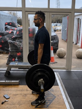 Habeeb after his four-month cut at 74.4kg, standing with a loaded barbell at Definition, Peterborough