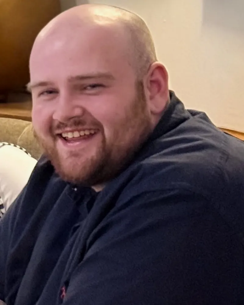 Ryan before, at around 182kg, smiling at a table in March 2025