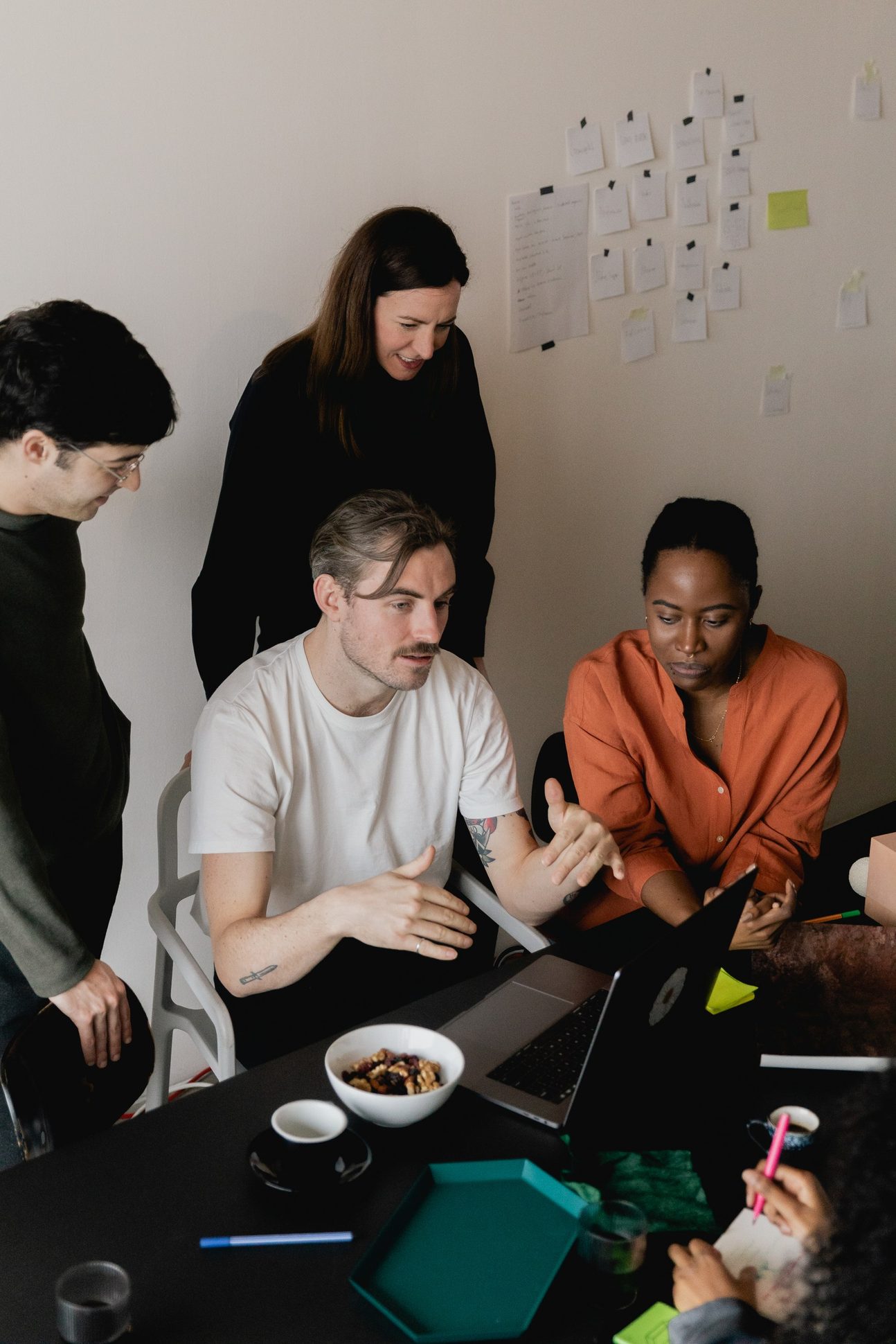 A team gathered around a laptop in discussion