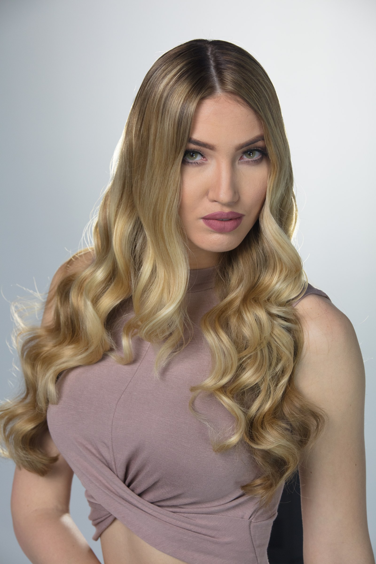 Blonde model with long styled waves in a studio beauty portrait.
