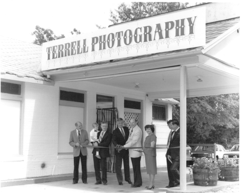 Andrew as a child with his father at the ribbon cutting for Terrell Photography