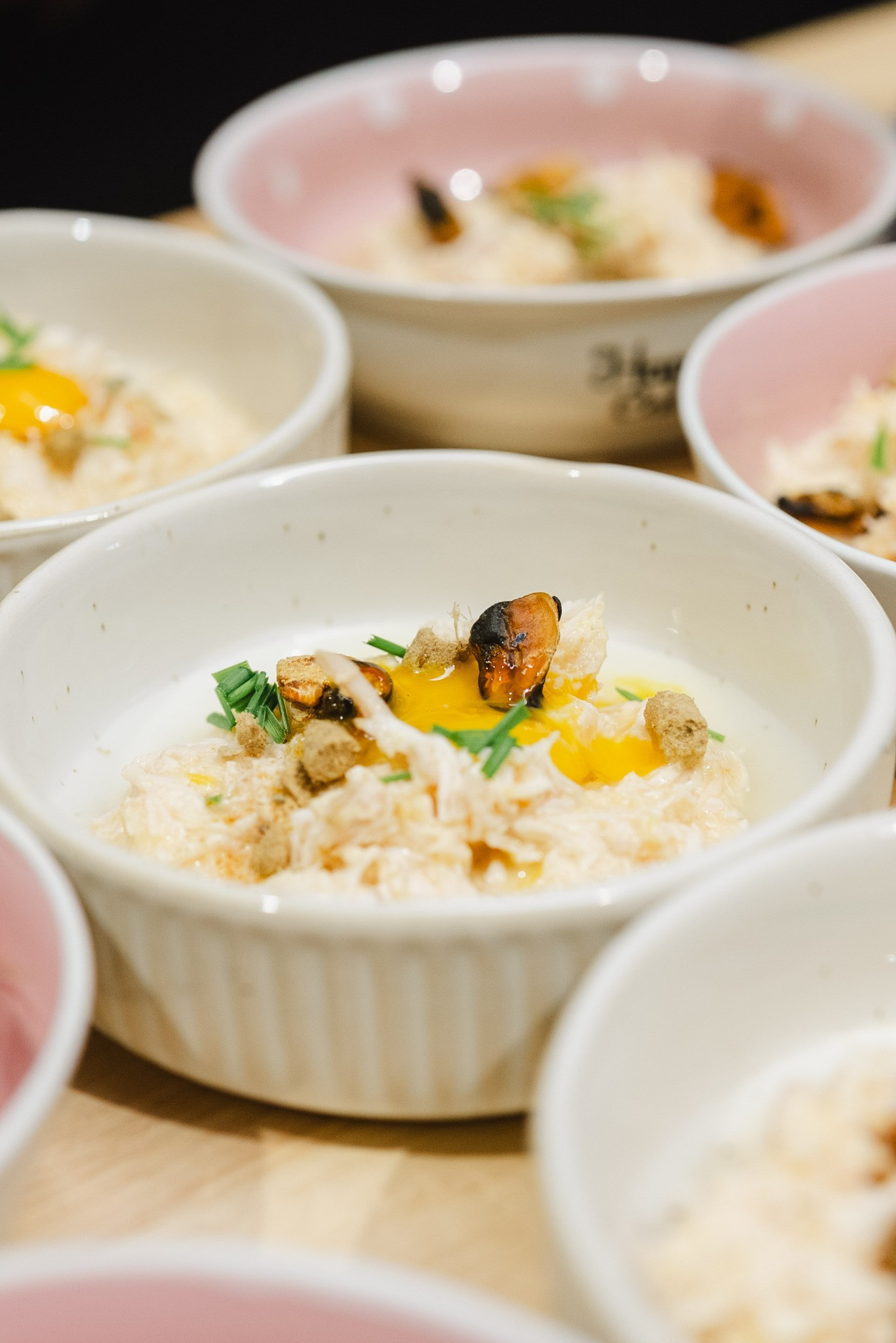 Close-up of a freshly prepared raw cat food bowl with quail egg and herbs