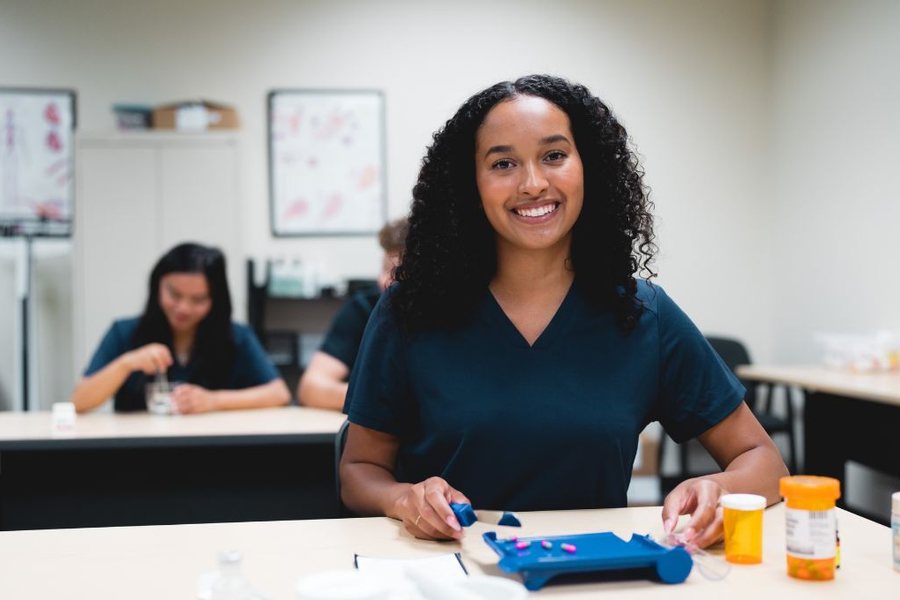 Pharmacy technician student practicing in a lab classroom