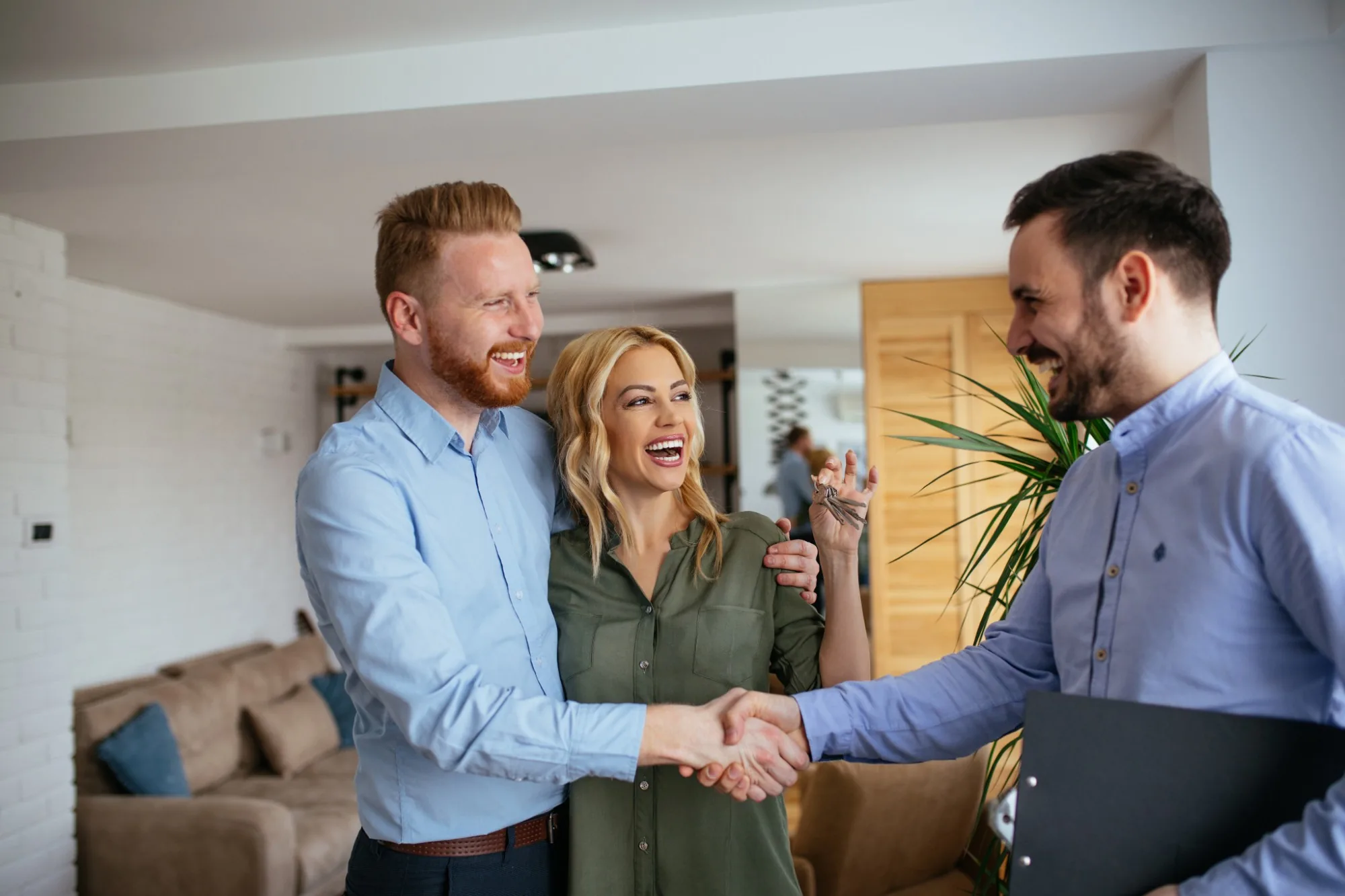Buyers shaking hands with an adviser in a home