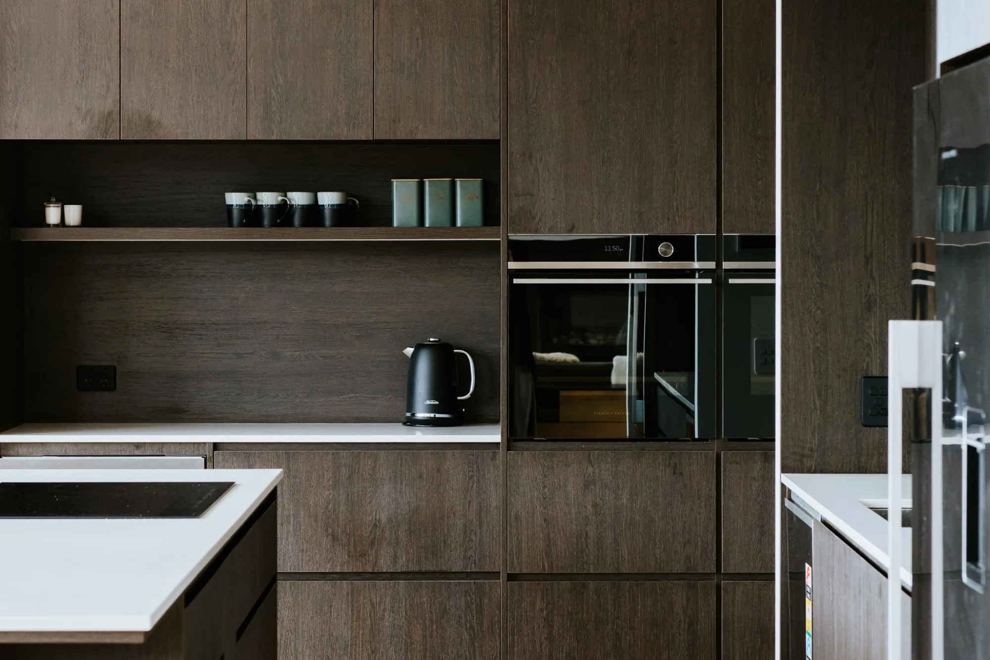 Dark timber kitchen with integrated appliances