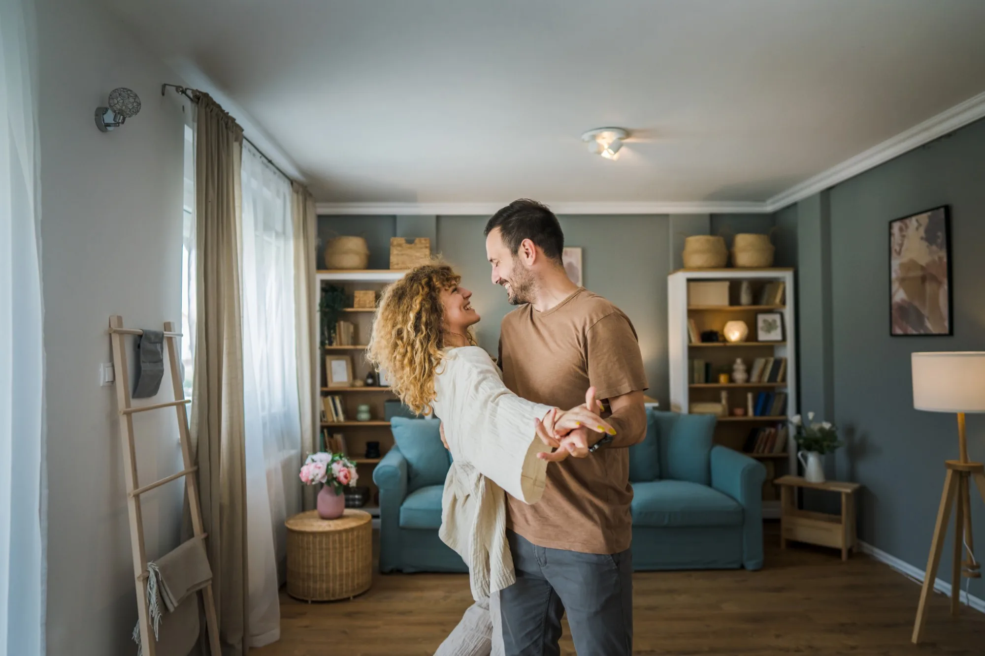 Couple dancing in the living room of their new home