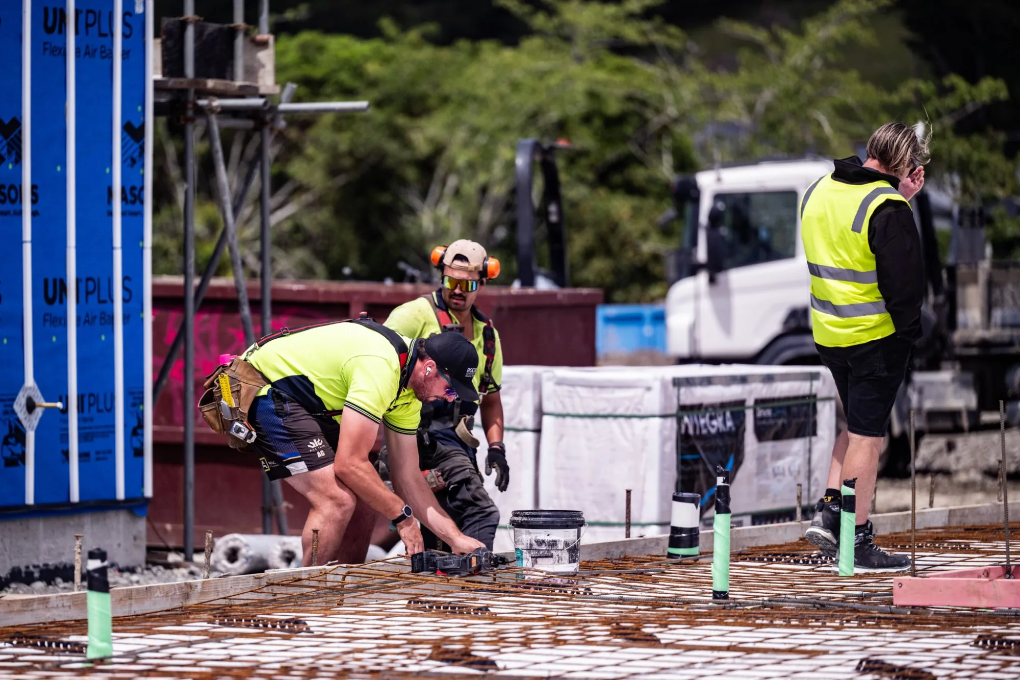 Construction crew laying reinforcing steel on a building site