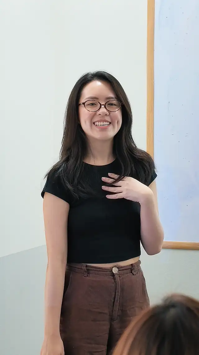 Course participant smiling mid-presentation during a Singapore public speaking course