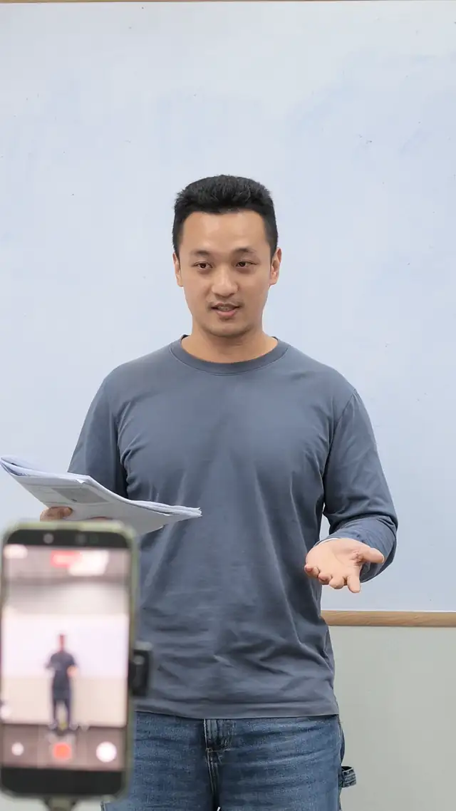 Participant practising a speech from notes while being filmed at a Singapore course