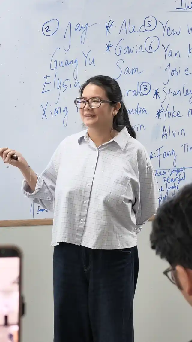 Course participant presenting at the whiteboard during a public speaking course in Singapore