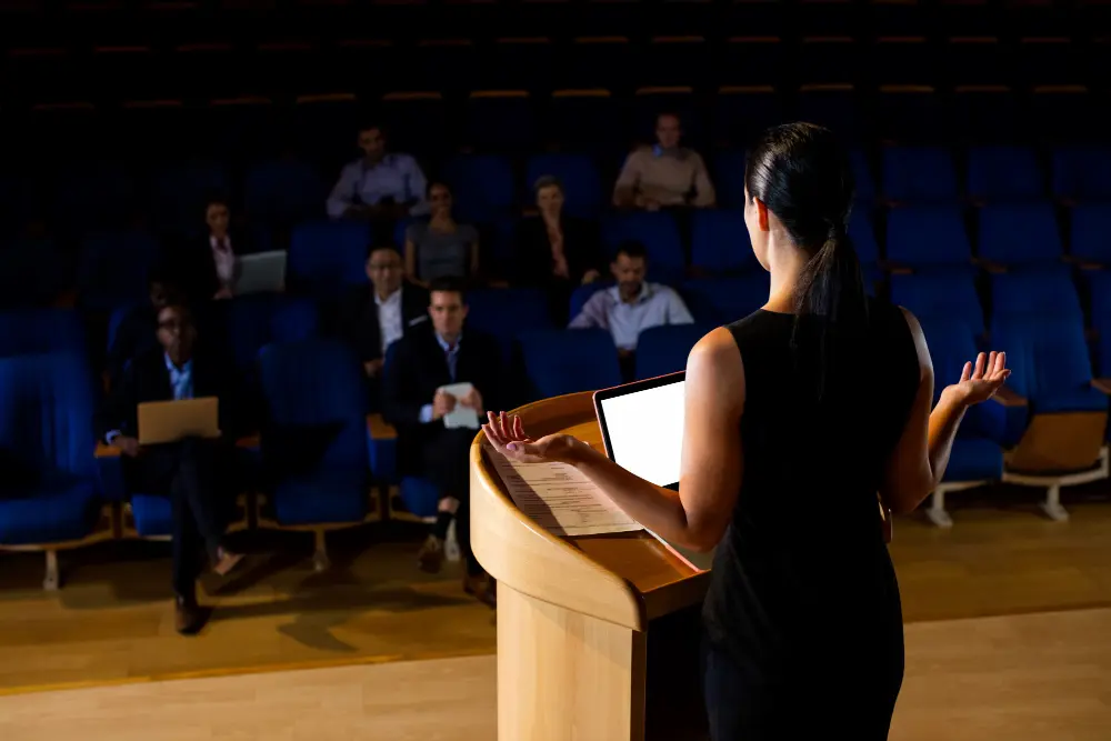 Smiling presenter holding his notes as he speaks to a group