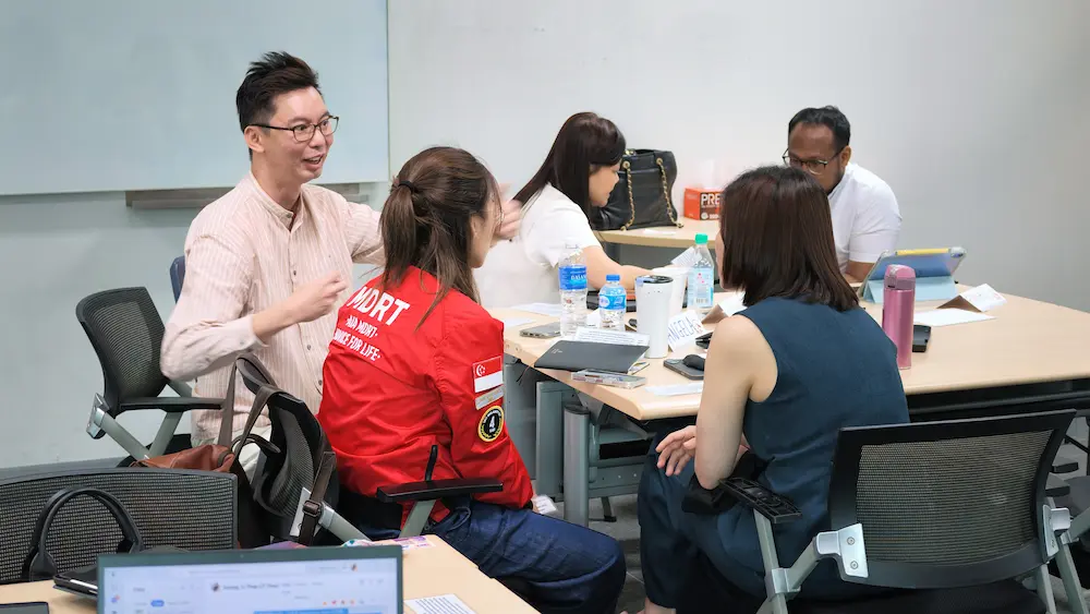Participants talking together at their tables during a presentation skills workshop