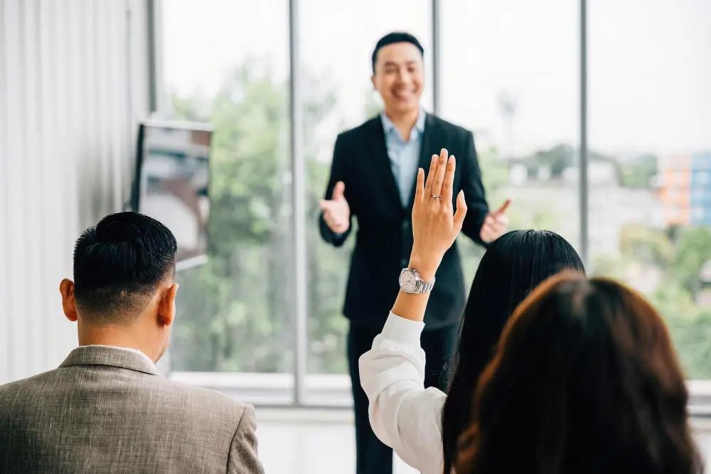 A presenter speaking to a small audience in a meeting room
